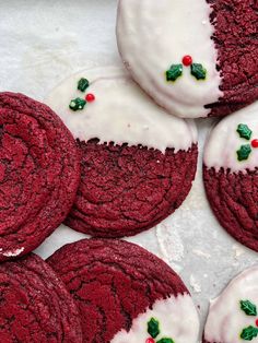 red velvet cookies decorated with white frosting and holly leaves on top are arranged in a circle