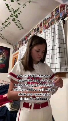 a girl in a baseball uniform looking down at her cell phone with the caption, don't go on a saturday night and you're trying to fly before hitting a yellow bed