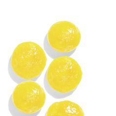 four lemons sitting on top of each other in the middle of a white surface