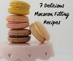 a stack of macaroons sitting on top of a pink cake plate with the words delicious macaron filling recipes