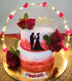 a wedding cake decorated with red roses and a couple holding hands on top of it