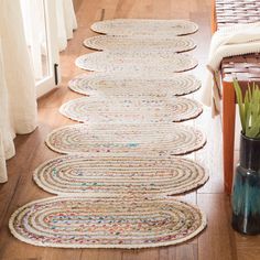 the rugs are lined up on the floor in front of the window and vase with flowers