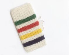 an apple logo is placed on top of a colorful striped knitted iphone case,