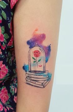 a woman's arm with a tattoo on it that has a rose in a glass dome