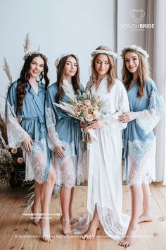 three bridesmaids in blue robes and flower crowns pose for a photo with their bouquets