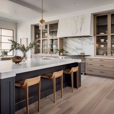 a kitchen with marble counter tops and wooden stools in front of the center island