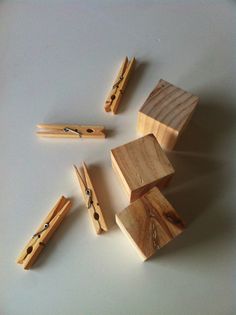 several pieces of wood with clothes pins sticking out of them on a white table top