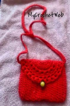 a red crocheted purse sitting on top of a white towel