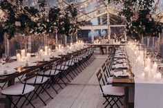 the tables are set up with candles and flowers in vases for an elegant wedding reception