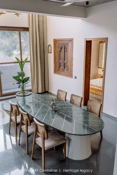 a dining room table and chairs in front of a window