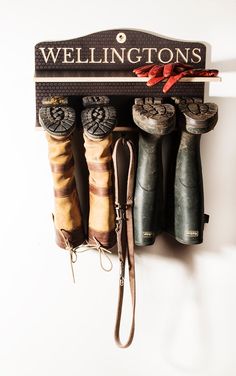 a coat rack with umbrellas hanging from it's sides and the words wellingtons written on it