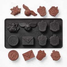 an assortment of chocolate molds on a baking sheet, with stamps and sealers