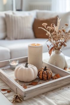 a tray with candles and pumpkins on it