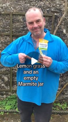 a man is holding up a lemon grass and an empty marmite jar in his hands