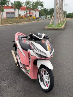 a pink and white motorcycle parked on the street