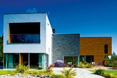 two modern houses with large windows on each side and landscaping around the front yard area