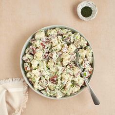 a bowl filled with salad next to a spoon