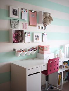 there is a desk and chair in this child's room with striped wallpaper