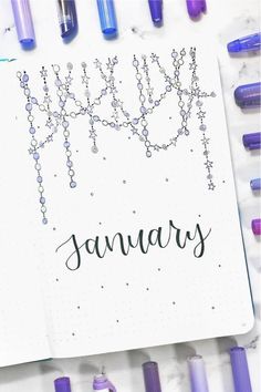 an open notebook with the word january written in black ink on it and lots of purple markers