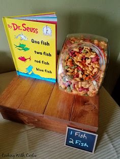 a wooden box filled with fish next to a book