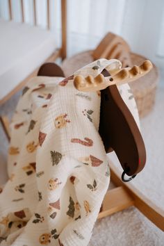 a wooden rocking horse with a blanket on it's back in a nursery room