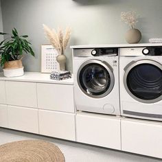 a washer and dryer sitting on top of a white cabinet in a room