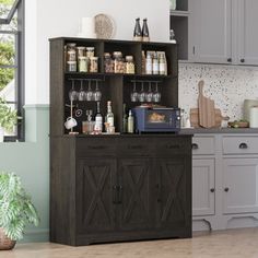 an open cabinet in the middle of a kitchen with lots of bottles and glasses on it