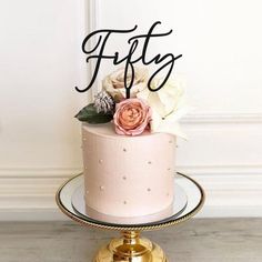 there is a pink cake with flowers on top and the word one written in cursive letters