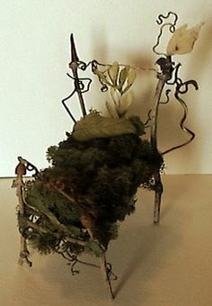 a sculpture made out of branches and flowers on a table