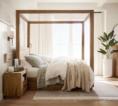 a bed with white linens and pillows in a bedroom next to a large window