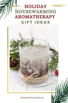 a glass filled with water and snow sitting on top of a table next to pine branches