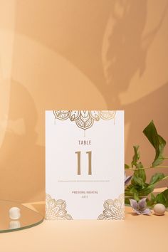 a table number sitting on top of a table next to a vase filled with flowers