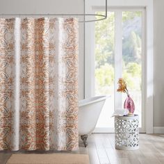 an orange and white shower curtain in a bathroom next to a bathtub with a window