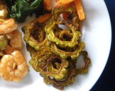 a plate with shrimp, broccoli and carrots on it next to some other food