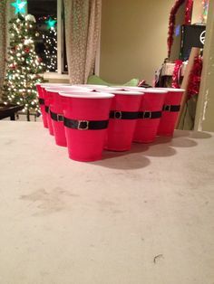 three red buckets sitting on top of a table next to a christmas tree in a living room