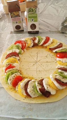 a pizza with tomatoes, cheese and other toppings on it sitting on a table