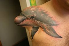 a man with a dolphin tattoo on his chest