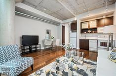 a living room filled with furniture and a flat screen tv on top of a wooden floor