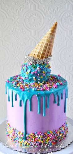 a cake decorated with sprinkles, ice cream and an icecream cone