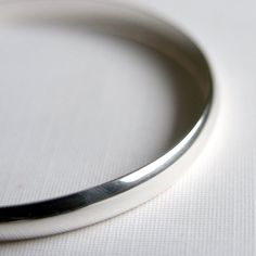 This gorgeous and  simple bangle has been handmade in sterling silver and given a super shiny finish.  It is a solid and comfortable bracelet that will work perfectly everyday and is sure to become a staple in your life.  Wear it alone or stacked with other bangles.Measures approx. 6mm x 2mmAvailable in,X Small 2.25 inches diameter,  7.5 inch circumferenceSmall 2.5 inches diameter, 8 inch circumferenceMedium 2.75 inches diameter, 8.5 inch circumferenceLarge 3 inches diameter, 9 inch circumferenc Sterling Silver Bracelet With Polished Finish For Everyday, Polished Sterling Silver Bracelet For Everyday, Classic Adjustable Sterling Silver Bracelet With Shiny Finish, Classic Sterling Silver Bracelets With Polished Finish, Classic Silver Jewelry With Smooth Finish, Everyday Silver Jewelry With Polished Edges, Silver Jewelry With Smooth Finish And Round Shape, Everyday White Gold Sterling Silver Bracelet With Polished Finish, Sterling Silver Jewelry With Smooth Finish For Gifts