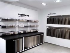 the interior of a showroom with many different color samples on shelves and flooring