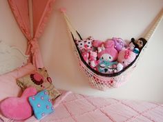 a hammock filled with lots of stuffed animals on top of a pink bed