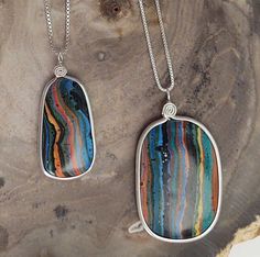 "Choice of 3 Fun Amazing Rainbow Calsilica Pendant Necklaces! These Multi color stones are perimeter wire wrapped with Sterling Silver by us. We finish them with their simple design, which enhances them while bringing out the individual characteristics and colors of each pendant! This stone is Mostly man made, while using the natural calcite as a base! The perimeter wire wrap holds the stone tight so they do not break like other designers slab pendants that are only drilled. The swirl at the top Multicolor Wire Wrapped Pendant Jewelry, Multicolor Necklace With Large Oval Pendant, Multicolor Wire Wrapped Pendant Necklace, Handmade Multicolor Oval Pendant Jewelry, Unique Multicolor Oval Pendant Jewelry, Multicolor Necklace With Large Stone For Gift, Unique Multicolor Large Stone Jewelry, Unique Multicolor Jewelry With Large Stone, Multicolor Oval Pendant For Jewelry Making