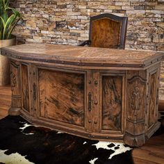 an old wooden desk in front of a brick wall and cowhide rug on the floor