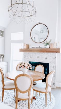 a dining room table with chairs around it and a mirror on the wall above it