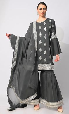 Step into the spotlight with our breathtaking 3-piece Garara Set, meticulously crafted to elevate your style to new heights. Adorned with intricate silver zari and foil work embroidery, the kurti exudes an aura of timeless elegance, while the heavy foil border on the kurta and garara hem adds a touch of opulence. Each motif tells a story of exquisite craftsmanship, shimmering gracefully with every movement. The ensemble is completed with a dupatta featuring a matching foil border, tying the look together seamlessly. Perfect for special occasions, this ensemble promises to make you the epitome of grace and sophistication, ensuring all eyes are on you wherever you go. Size & FitModel height is 5’9’ and is wearing a Small sizeMaterial & CareMaterial: Chiffon Care: Gentle machine wash in cold White Sharara, Sharara Set, Wedding Clothes, All Eyes, Wedding Outfit, 3 Piece, Bell Sleeves, Elevate Your Style, Timeless Elegance