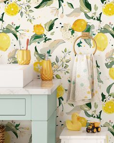 a bathroom with lemons and flowers on the wall next to a white counter top