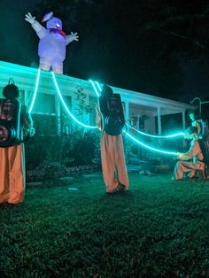 some people in costumes are standing outside at night with lights on their heads and arms