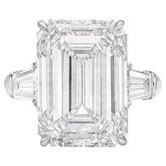 This magnificent ring features a GIA-certified 7.01 carat emerald-cut diamond, set in luxurious 18K white gold. The diamond's F color grade ensures exceptional whiteness and brilliance, while its VVS2 clarity grade means it has nearly flawless purity, with only minute inclusions visible under magnification. The elegant emerald cut enhances the stone's clarity and sophisticated, elongated shape. With excellent polish and symmetry, the diamond reflects light with stunning precision. Flanked by tap Oval Cut Diamond Engagement Ring, Rare Diamond, Emerald Cut Diamond Ring, Vvs Diamond, Future Engagement Rings, Emerald Engagement Ring Cut, Emerald Cut Diamond, Expensive Jewelry, Oval Cut Diamond