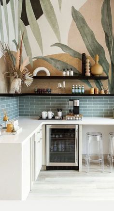 the kitchen is decorated with tropical wallpaper and white counter tops, along with bar stools